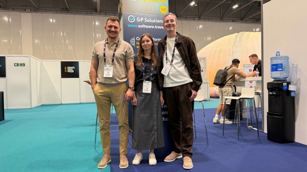 Full body shot of GP Solutions' team posing in front of the GP Solutions stand at a busy exhibition.