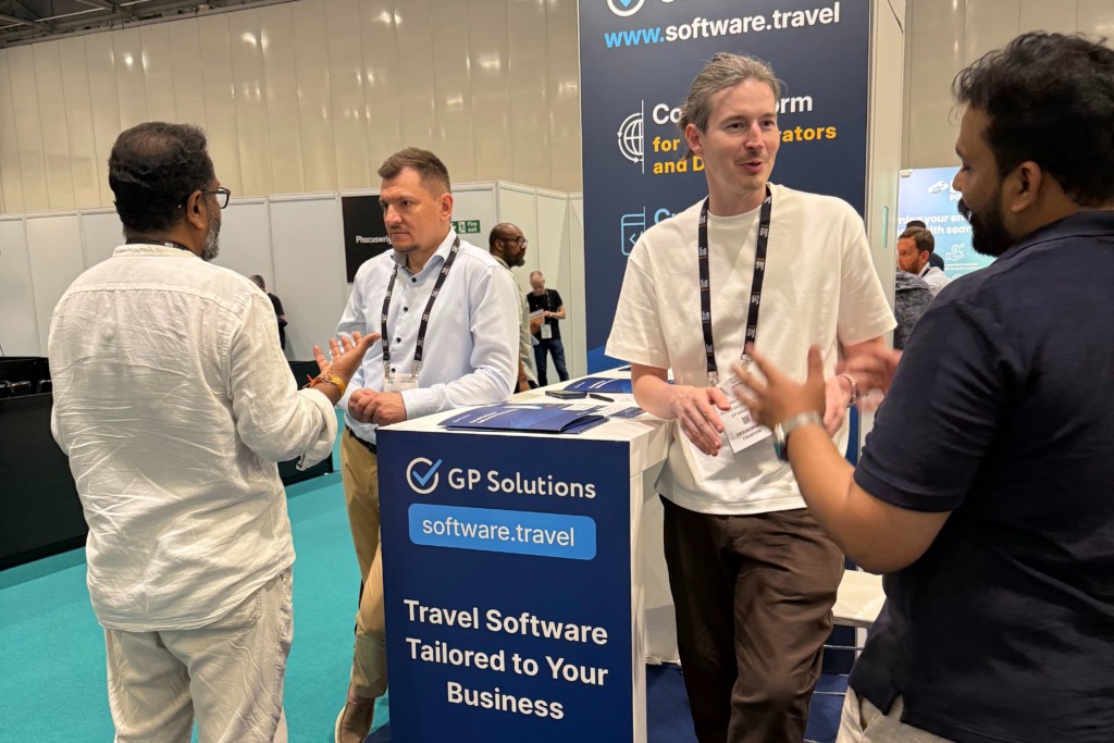 Three men having an active conversation at the GP Solutions exhibition booth during the Travel Tech Show
